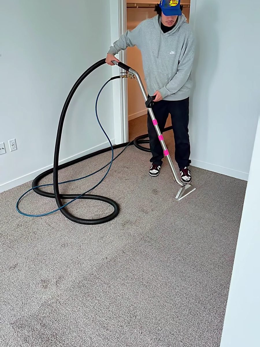 Technician extracting a bedroom carpet with a cleaning wand