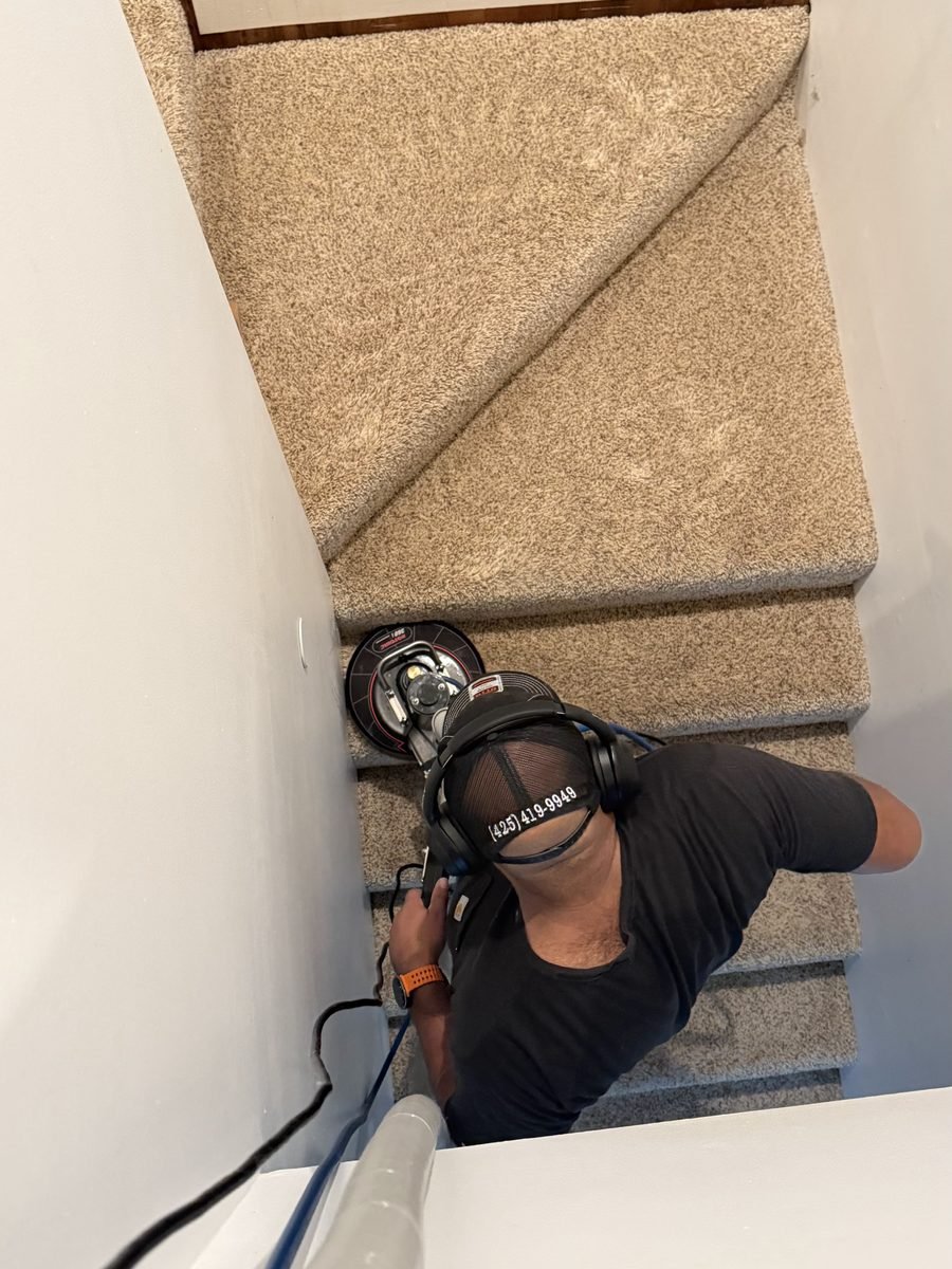 Olsen Restoration technician deep cleaning carpeted stairs with a rotary extraction machine
